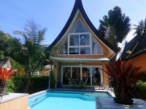 a house with a swimming pool in front of a house at Klong Son Beachfront Apartments in Ko Chang