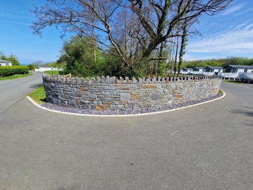 a stone retaining wall on the side of a road at HARRIES LODGE QUAY WEST milkwood way in New Quay