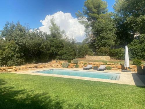 uma piscina num quintal com cadeiras e um quintal em Magnifique Villa à 10 mn des Plages avec Piscine pour 6 Personnes em Le Beausset