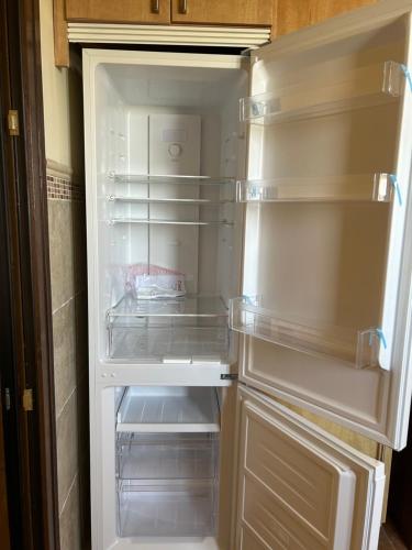 an empty refrigerator with its door open in a kitchen at A estribor in Isla Canela