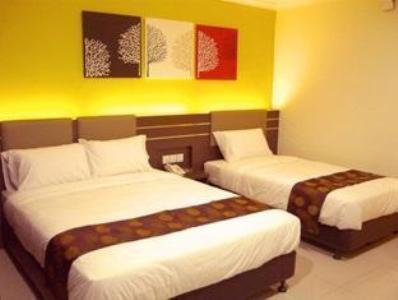 a hotel room with two beds in a room at GM Holiday Hotel in Lumut