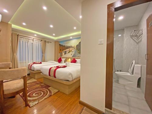 Habitación de hotel con 2 camas y baño en Hotel Malati en Katmandú