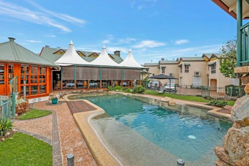 a swimming pool in a yard with a building at Haven @ Lake Tinaroo Resort in Tinaroo