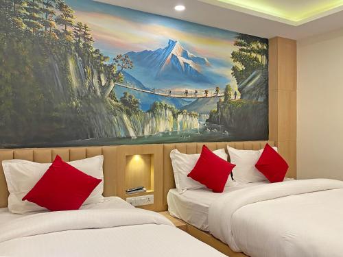 カトマンズにあるHotel Malatiの絵画が飾られた客室で、赤い枕付きのベッド2台が備わります。