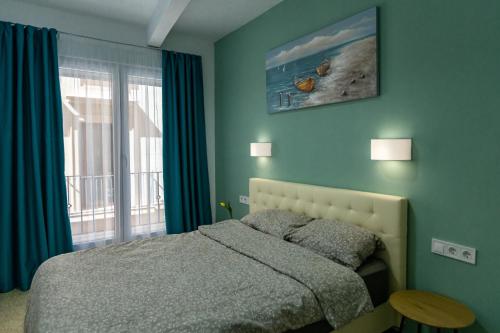 een slaapkamer met een bed met blauwe muren en een raam bij NEW Beach Apartments in Alicante