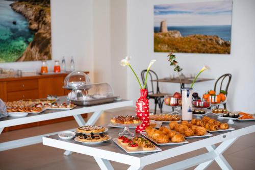 een tafel met diverse zoete deegwaren en andere etenswaren bij Agriturismo Panacea in Santa Cesarea Terme