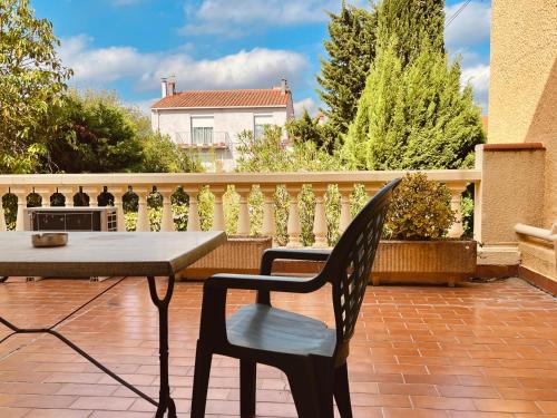 einen Tisch und einen Stuhl auf einer Terrasse in der Unterkunft Hôtel le Nid in Argelès-sur-Mer