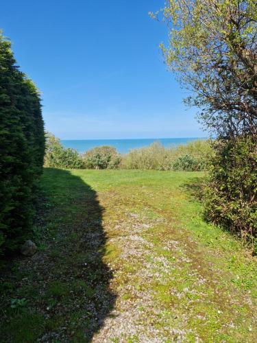 a path through a field with the ocean in the background at Harries Lodge ocean in New Quay