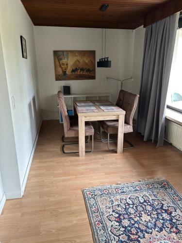 a dining room with a table and chairs and a rug at FeWo beim Schmetterlings Park in Buchholz in der Nordheide
