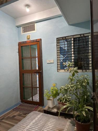 a room with a door and potted plants in it at Mangal kripa homestay in Ujjain