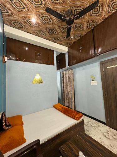 a small kitchen with a white counter and brown cabinets at Mangal kripa homestay in Ujjain
