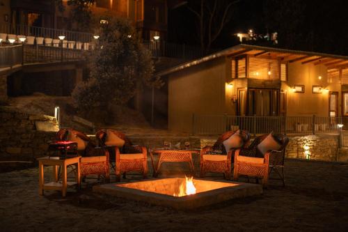 a fire pit in front of a house at night at Rudraa resort and restaurant in Hawālbāgh