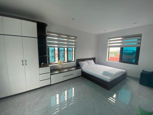 ein Schlafzimmer mit einem Bett und zwei Fenstern in der Unterkunft Hong Kong Hotel in Haiphong