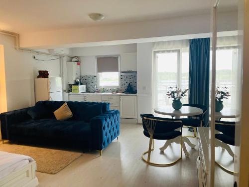 Una sala de estar con un sofá azul y una mesa. en Air Residence, en Otopeni