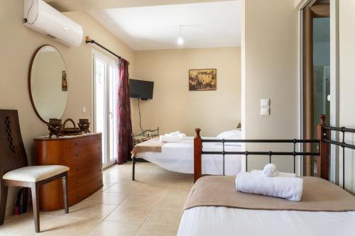 een slaapkamer met 2 bedden en een spiegel bij Philip estate in Ágios Nikólaos