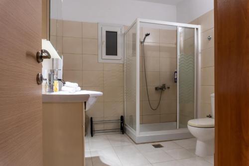 een badkamer met een douche, een wastafel en een toilet bij Philip estate in Ágios Nikólaos