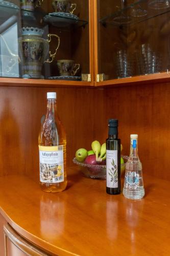 two bottles of alcohol and a bowl of apples on a counter at Philip estate in Koiliomenos