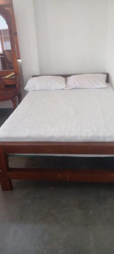 ape gedrae في بيرادنيا: سرير بإطار خشبي مع مرتبه بيضاء