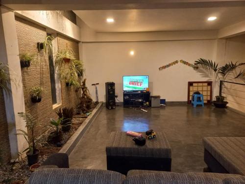 ape gedrae في بيرادنيا: غرفة معيشة مع تلفزيون وأريكة وطاولة