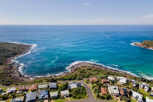 an aerial view of a beach with houses and the ocean at Merry Beach Getaway in Kioloa