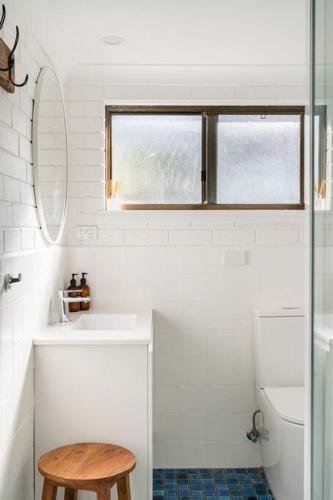 a bathroom with a sink and a toilet and a window at Merry Beach Getaway in Kioloa