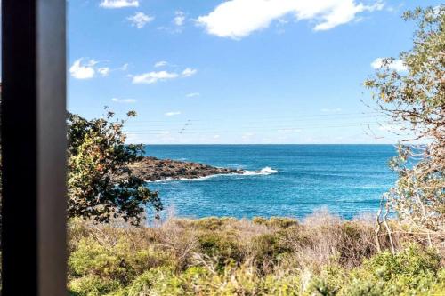 a view of the ocean from a train window at Merry Beach Getaway in Kioloa
