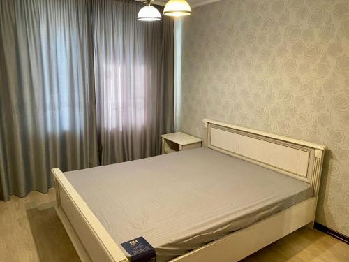 um pequeno quarto com uma cama num quarto em UKA Comfort, 3х комнатная в центре. em Öskemen