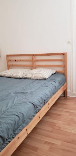 un lit avec un cadre en bois dans une chambre dans l'établissement Appartement 2 pièces 20 m2 gare Trouville, à Trouville-sur-Mer