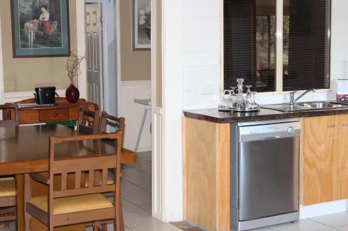 a kitchen and dining room with a sink and a table at Windswept Country Retreat in Ballandean