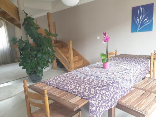 une table de salle à manger avec une nappe violette et une plante en pot dans l'établissement Chambres privées dans maison zen, à Dijon