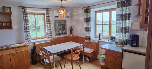 a kitchen with a table and chairs and windows at Landhaus auf der Alm 