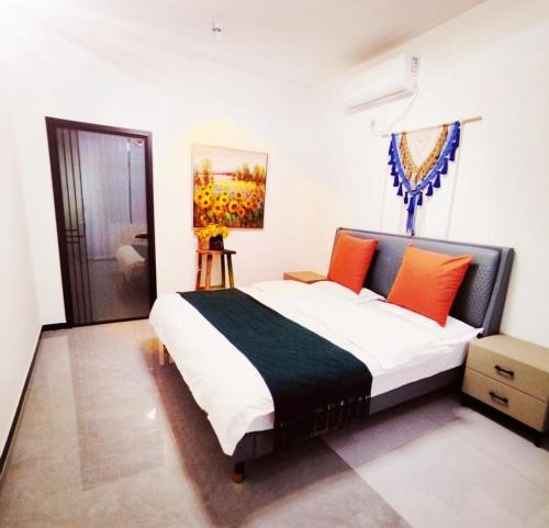 1 dormitorio con 1 cama grande con almohadas de color naranja en Flower Yard, en Huairou