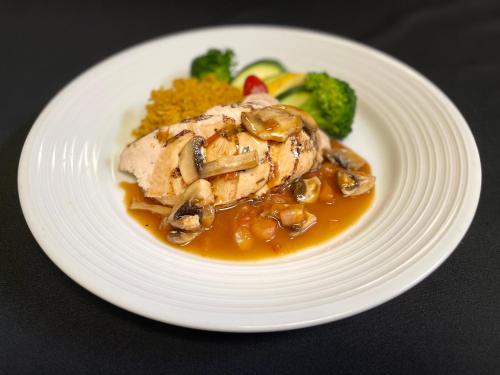 a plate of food with chicken with mushrooms and vegetables at Holiday Inn Montreal Longueuil by IHG in Longueuil