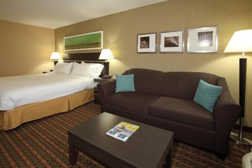 a hotel room with a couch and a bed at Holiday Inn Express Hotel & Suites Vernon, an IHG Hotel in Vernon