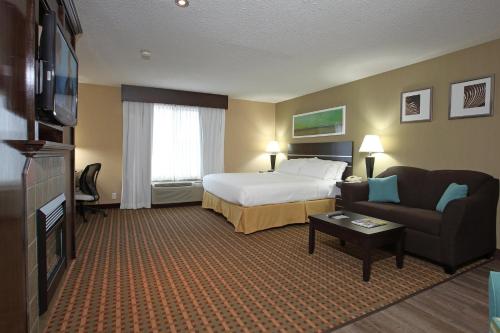 a hotel room with a bed and a couch at Holiday Inn Express Hotel & Suites Vernon by IHG in Vernon