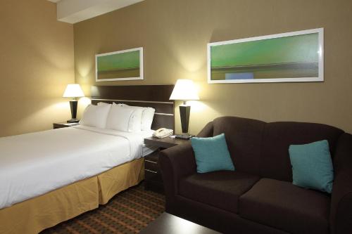a hotel room with a bed and a couch at Holiday Inn Express Hotel & Suites Vernon by IHG in Vernon