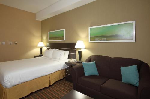 a hotel room with a bed and a couch at Holiday Inn Express Hotel & Suites Vernon by IHG in Vernon