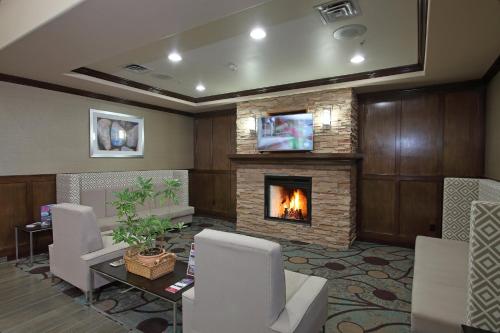 a living room with a fireplace and a table and chairs at Holiday Inn Express Hotel & Suites Vernon, an IHG Hotel in Vernon