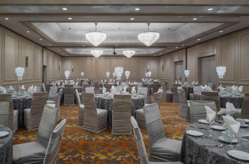 a ballroom with tables and chairs and chandeliers at Holiday Inn Winnipeg-South by IHG in Winnipeg