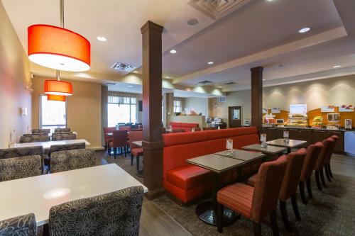a restaurant with tables and chairs and a bar at Holiday Inn Express & Suites Riverport Richmond by IHG in Richmond