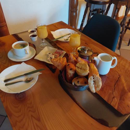 einen Tisch mit einem Tablett mit Brot und Tassen Kaffee in der Unterkunft Cap'tain Cook in Caurel