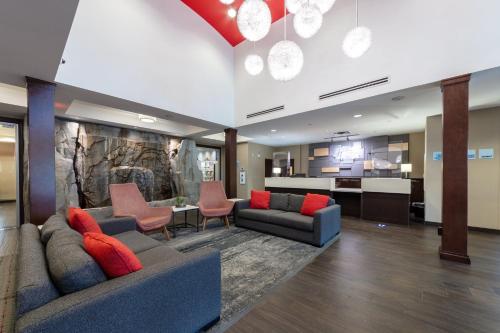 a lobby with couches and chairs and a kitchen at Holiday Inn Express & Suites Riverport Richmond by IHG in Richmond