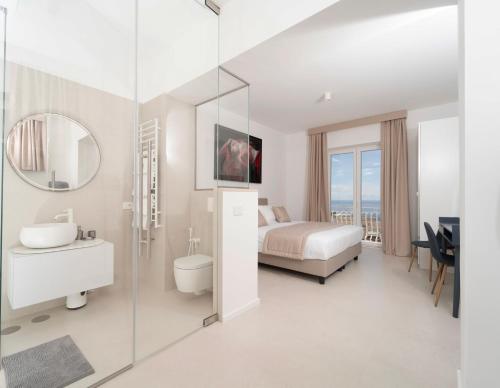 a bedroom with a bed and a sink and a mirror at La Prora Apartments in Capri