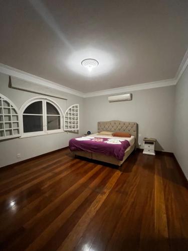 um quarto com uma cama e piso em madeira em Quarto super luxo Alphaville em Barueri