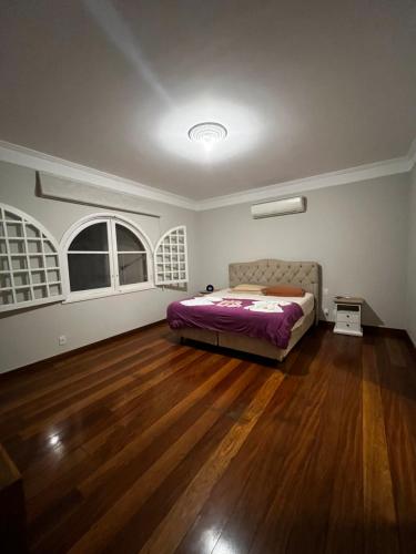 um quarto com uma cama e piso em madeira em Quarto super luxo Alphaville em Barueri