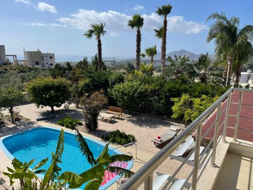 balcón con piscina y palmeras en Villa Chrysa Rhodes, en Afantou