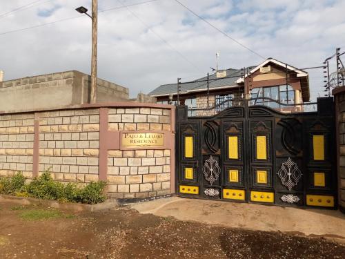 un bâtiment noir avec des portes jaunes devant un bâtiment dans l'établissement Paju & Lelujo Residence, 