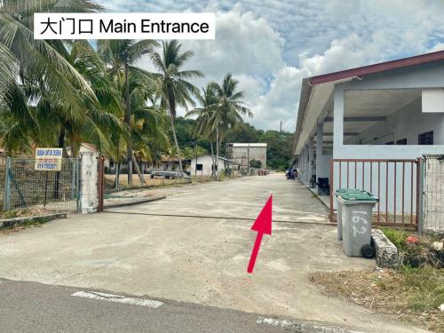 an empty street with a red arrow pointing towards a building at Nature Camp House 2km Jeti Mersing Centre in Mersing