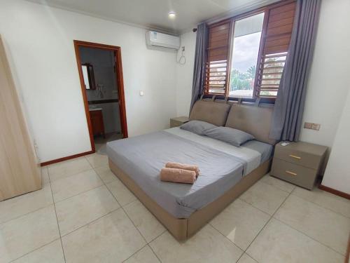 a bedroom with a bed with a towel on it at Exquisite 3-Bedroom Unit With Free Parking. in Nadi