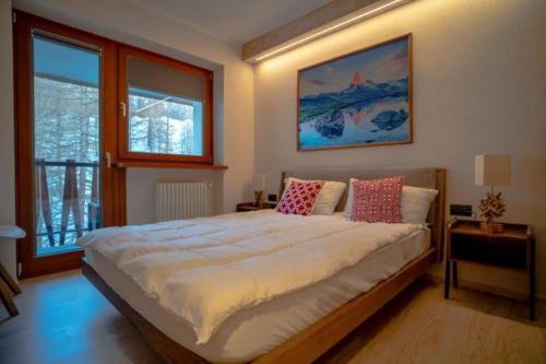 a bedroom with a large bed with pillows on it at Stylish three rooms in Cervinia 82 in Breuil-Cervinia